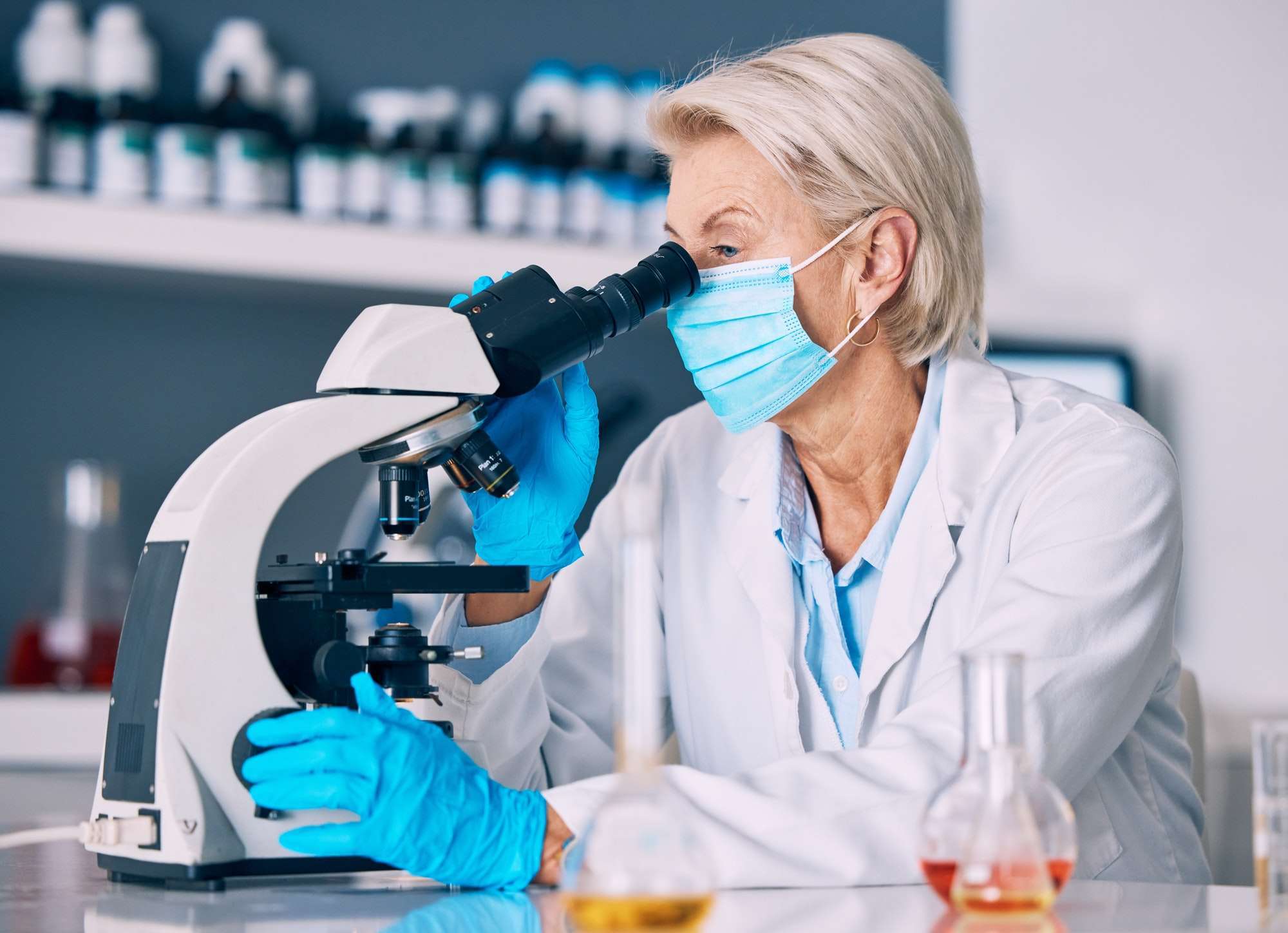 Microscope, senior woman and science research with testing for a pharmaceutical or lab study. Chemi